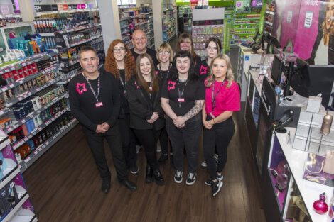 A group of people standing in front of a store.