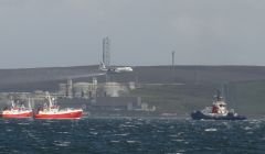 A Hercules aircraft spraying dispersants while fishing boats and a Sullom Voe harbour tug pretent to deploying booms - Photo: Hans J Marter, Shetland News