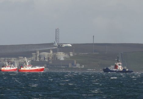 A Hercules aircraft spraying dispersants while fishing boats and a Sullom Voe harbour tug pretent to deploying booms - Photo: Hans J Marter, Shetland News