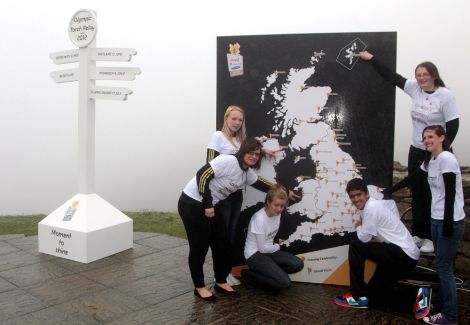 Ambassadors Mhairi Gifford from Shetland (top right corner), 18 year old Danielle Pryce from Aberystwyth, Wales; 14 year old Cassie Munro from Holywood, Belfast, Northern Ireland; 19 year old Sophie Lowe from Norwich, East of England; 14 year old Amy Johns from Penzance, Cornwall; and 14 year old Simran Dhingra-Smith from Newham, London point to their respective homes on the map during London 2012 Olympic Torch Relay Briefing - Photo by Matt Cardy