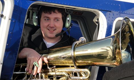 Tuba player John Whitener boarding the plane to Foula, on Friday morning.