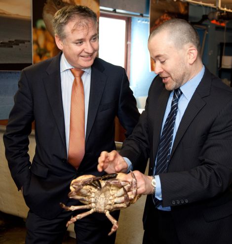 Fisheries secretary Richard Lochhead (left) invites NAFC Marine Centre's head of fisheries science Dr Martin Robinson to show him just how hard a crab can grip someone's finger. Pic. Billy Fox