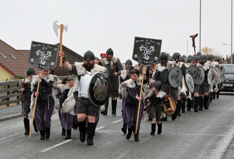 Delting Up Helly Aa Jarl's Squad hit by a wintry shower while marching through Brae on Friday morning.