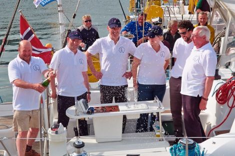 Celebrating victory are the crew of the Erin with crew member Ken Brown opening the champagne - Photo: Chris Brown 