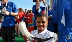 Standard bearer and team mascot Aaron holding the horn in which Andrea Strachan delivered Shetland's pint (of water) for the opening ceremony. Photo Andrew Inkster