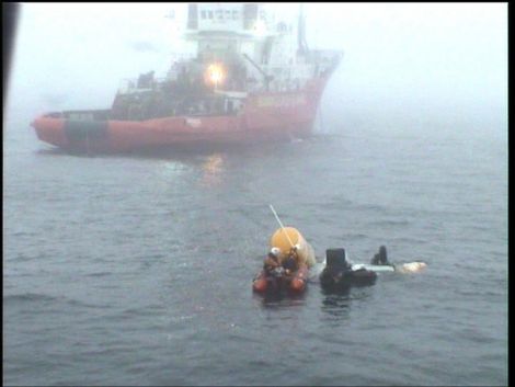 RNLI team with helicopter wreckage; the Coastguard emergency towing vessel Herakles in the background - Photo: RNLI