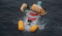 The upturned helicopter floating in the sea - Photo: Peter Hutchison/ShetNews