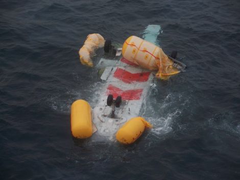 The upturned helicopter floating in the sea - Photo: Peter Hutchison/ShetNews