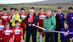 Bressay Sports Club chairman Kenny Groat looks proudly on as footballing veteran Jim Peterson cuts the ribbon to officially open the Bressay sports pitch. Photo Mark Berry