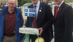 Education secretary holds the St Kilda boat presented by CURE secretary Gordon Thomson (left) with Shetland MSP Tavish Scott. Photo CURE