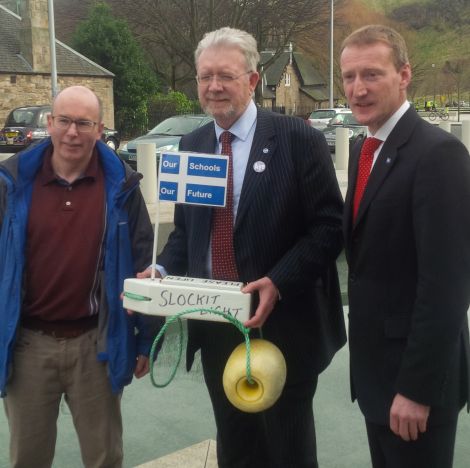 Education secretary holds the St Kilda boat presented by CURE secretary Gordon Thomson (left) with Shetland MSP Tavish Scott. Photo CURE