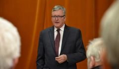 SNP minister Fergus Ewing speaking in Sandwick's Carnegie Hall on Monday night. Photo: Shetnews