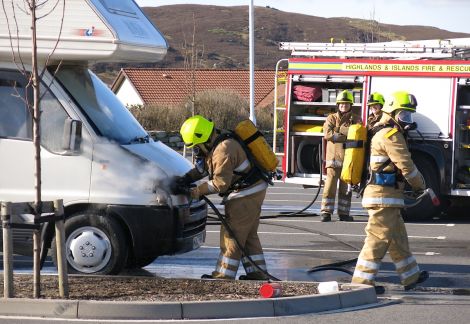 Firefighters using breathing apparatus and one hose reel jet to extinguish the fire in the engine compartment - Photo: Garry Sandison