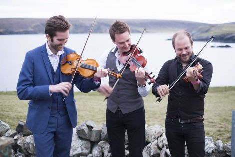 Nordic Fiddlers' Bloc, featuring Shetlander Kevin Henderson (centre), enjoying the fresh Fetlar air ahead of their Friday night concert. Photo: Floortje Robertson