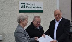 Charitable trust chairman Bobby Hunter receiving the petition from Sandy MacMillan and his wife Gail. Photo: Daniel Lawson