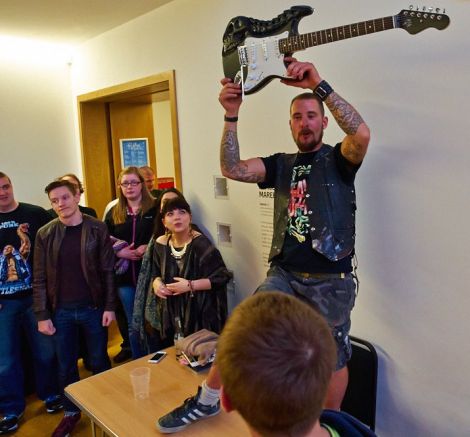 Dirk Robertson waves his coveted hand-carved guitar during the raffle. Photo Chris Brown