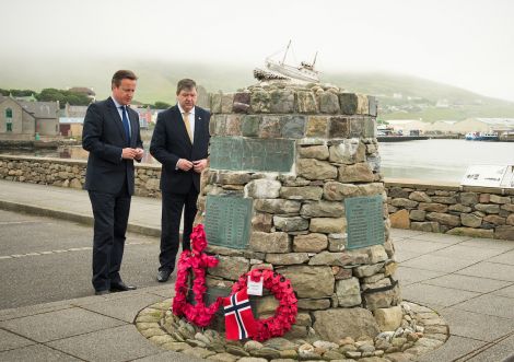 Cameron laying a wreath at the Shetland Bus memorial in Scalloway on Wednesday morning, as MP Alistair Carmichael looks on.