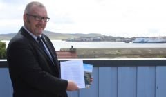 Shetland Islands Council leader Gary Robinson holds up the two pledges from the UK and Scottish governments for greater island powers following the independence referendum.