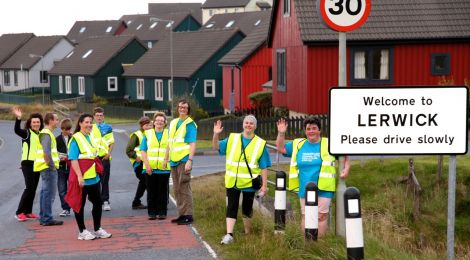 Happy faces as Liz reaches the Welcome to Lerwick sign on the old North Road. Photo: Barry Broadbent