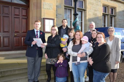 Urafirth parents handing over a petition calling on the SIC to save their school on Monday. Photo: Shetnews/Neil Riddell