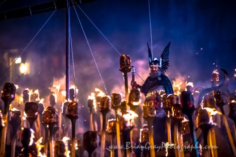 Guizer Jarl Olav Haraldsson cuts a spectacular figure as the torches give the night air a beautiful hue. Photo: Brian Gray