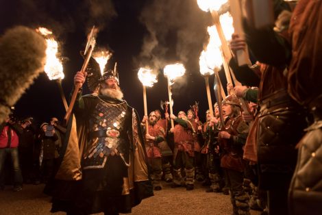 Guizer Jarl Neil Robertson bathed in firelight at Hay's Dock earlier in the day. Photo: Shetnews