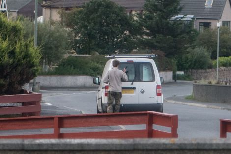 Barlow smashing the window of a white van parked in the area.