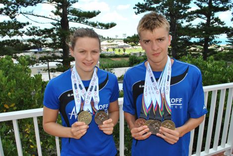 Swimmers Andrea Strachan and Felix Gifford with their haul of medals in Bermuda in 2013. Photo courtesy of SIGA