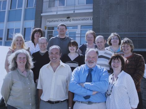 Staff gather to celebrate the completion of the association's 500th house (from left): Fiona Robertson, then chairman Jeff Goddard, then chief executive Robin Sandison, Susan Gray; middle row: Alison Coles, Arnie Arcus, Elaine Johnston, Paul Leask, Renee Pottinger; and back row: Avril Smith, Bryan Leask, Eunice Isbister, Melanie Dawson. 