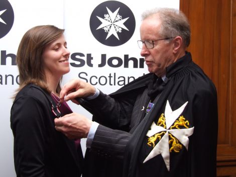 Jessica being presented with her award from Major General Mark Strudwick, Prior of St John Scotland.