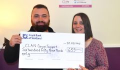 Walk organiser Adam Grzyb presenting money to CLAN Cancer Support's Shetland co-ordinator Dana Millarkie.