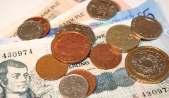 British pound coins and notes on a white background.