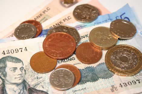 British pound coins and notes on a white background.