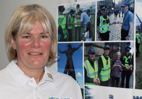 PC Carole Smith with photos of some of the young volunteers elsewhere in Scotland. Photo Chris Cope/Shetnews