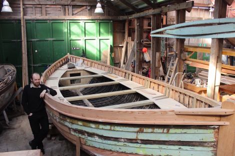 Shetland museum curator Ian Tait with the restored Oceanic lifeboat, now just in need of a lick of paint - Photo: Hans J Marter/ShetNews