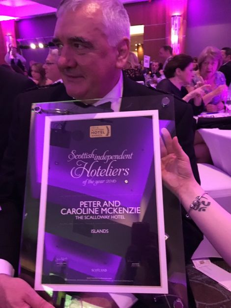 Peter Mackenzie holds up the award he and his wife Caroline won on Sunday night.