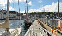 Yachts at pontoons in Lerwick's small boat harbour, with the town centre in the background.