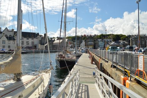 Yachts at pontoons in Lerwick's small boat harbour, with the town centre in the background.