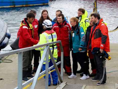 The crew being met by Shetland coastguard officers when they arrived in Scalloway, before being interviewed by the police about their experience and being taken to emergency accommodation. Photo Chris Cope/Shetnews