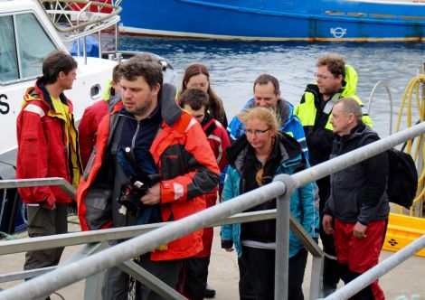 The Polish crew rescued from the yacht Miracle come ashore at Scalloway on Thursday evening, nine hours after escaping their blazing craft. Photo Chris Cope/Shetnews