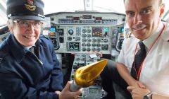 Wing commander Christine Copsey holding the baton in the cockpit of a Loganair Saab 340.