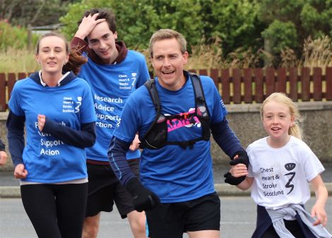 Benjamin Napier with his three children Maya, Rory and Roisin about to cross the finishing line at Lerwick's Bruce Crescent on Monday morning - Photo: Hans J Marter/ShetNews