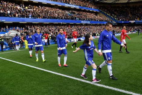 Mascot Macy coming out onto the Stamford Bridge turf alongside Cesar Azpilicueta. 