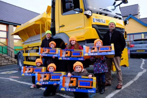 Councillors Steven Coutts (left) and Michael Stout (right) with the six pupils who chose the winning names for the gritters - Photo: SIC