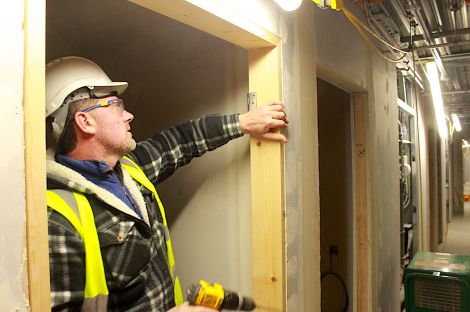 Door hinges are being put in place at one of the bedrooms in the halls of residence.