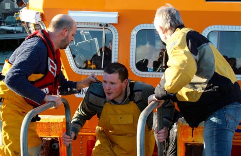 One of the Ocean Way fishermen being taken to safety at Lerwick Harbour on Friday morning - Photo: Chris Cope/Shetland News