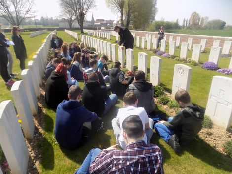 Pupils listening to a tour guide at Dartmoor Cemetery on the Somme.