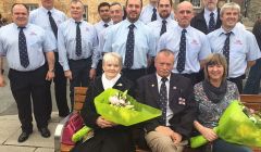 Seated on the memorial bench, from left, are Ian's mother Bridget Halvorsen and his wife Val Leask, with retired coxswain Hewitt Clark in the middle. Behind are the current crewmen. Photo: Davie Gardner.