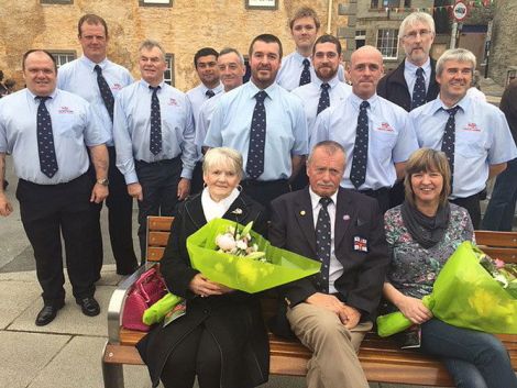 Seated on the memorial bench, from left, are Ian's mother Bridget Halvorsen and his wife Val Leask, with retired coxswain Hewitt Clark in the middle. Behind are the current crewmen. Photo: Davie Gardner.