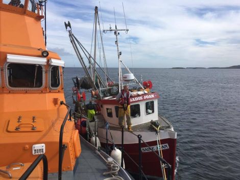 The creel boat Sadie Joan being taken under tow by the Lerwick lifeboat.